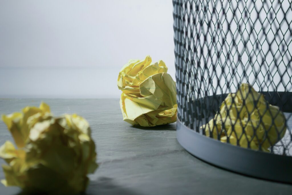 Waste basket with crumpled papers.